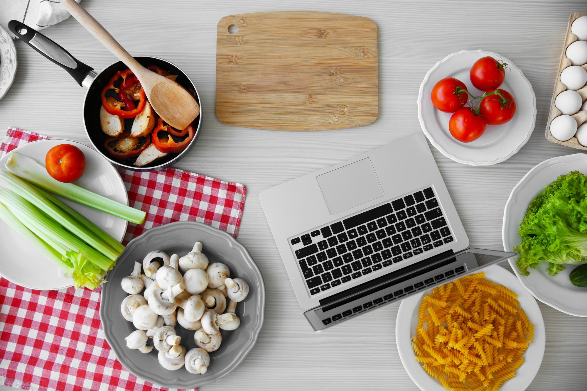 Modern kitchen workspace with tools and laptop for online cooking